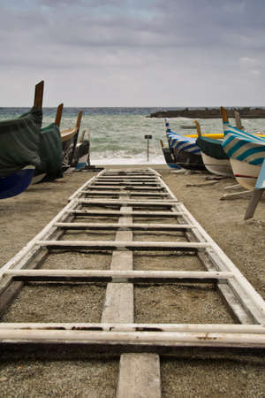 Beach with a boat and storm with threatening clouds coming from Mediterranean Sea, Italyの写真素材