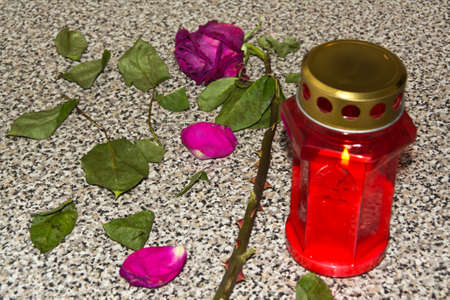 cemetery red lantern candle with red rose on the tombstone (selective focus)の写真素材