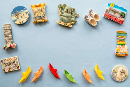 various souvenir magnets and paper ships arranged on the blue backgroundの写真素材