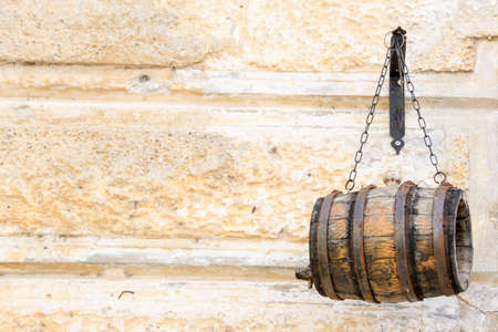 Small wooden barrel hanging on metal chainsの写真素材