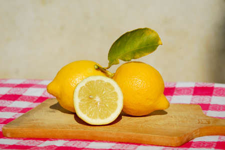 fresh yellow lemons on a wooden cutting boardの写真素材