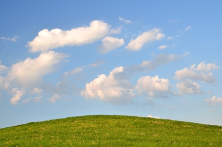 green field and clouds in the skyの写真素材