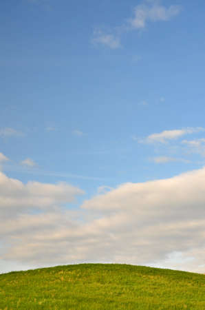 green field and clouds in the skyの写真素材