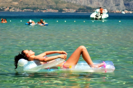beautiful teenage girl sunbathing on Adriatic waters, Croatiaの写真素材