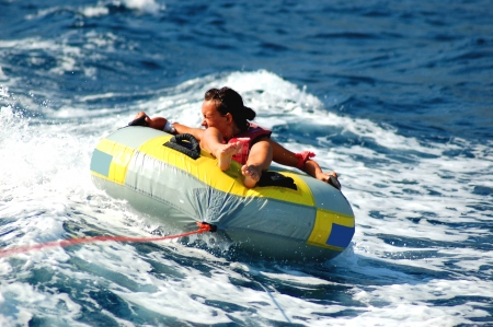 young girl dashing on tube on adriatic watersの写真素材