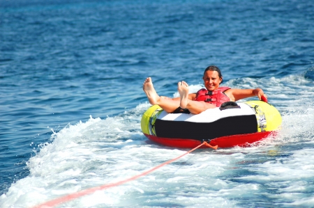 young girl dashing on tube on adriatic watersの写真素材
