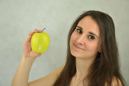 Beautiful attractive young girl is holding an appleの写真素材