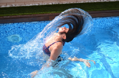 Beautiful attractive young girl having fun in a swimming poolの写真素材