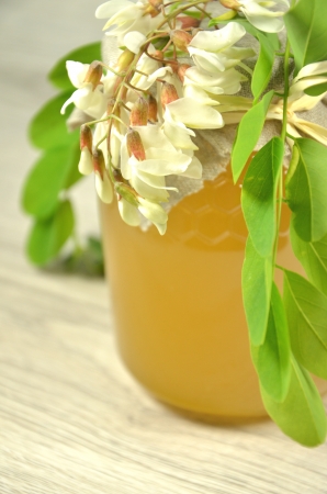 jar of fresh delicious honey with acacia flowers and honeycombの写真素材
