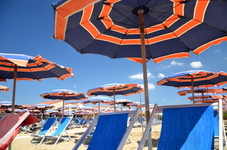 Colorful beach umbrellas and chairs on beautiful beach in Marina di Pisa, Tuscany in Italyの写真素材