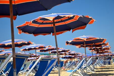 Colorful beach umbrellas and chairs on beautiful beach in Marina di Pisa, Tuscany in Italyの写真素材