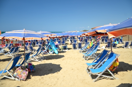 Colorful beach umbrellas and chairs on beautiful beach in Marina di Pisa, Tuscany in Italyの写真素材