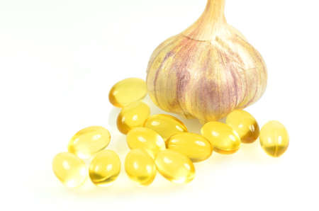 fish oil capsules and garlic isolated on white backgroundの写真素材