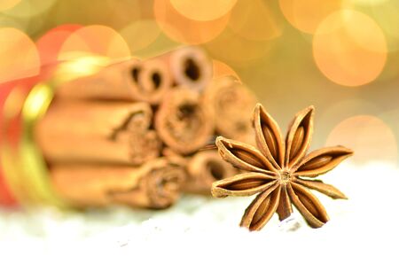 christmas spices, cinnamon sticks, anise star on bokeh backgroundの写真素材