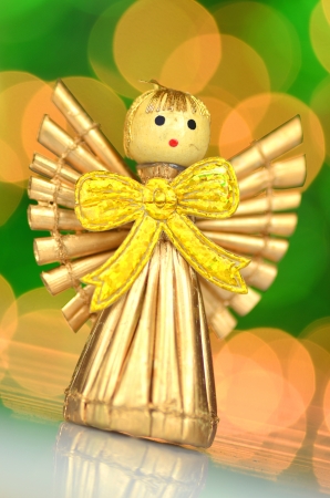 christmas decoration, golden angel made of straw against bokeh backgroundの写真素材