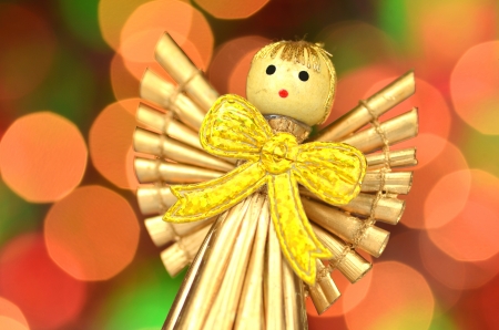 christmas decoration, golden angel made of straw against bokeh backgroundの写真素材