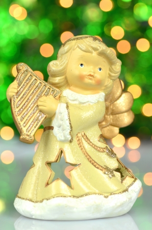 christmas decoration, figure of angel playing the harp against bokeh backgroundの写真素材