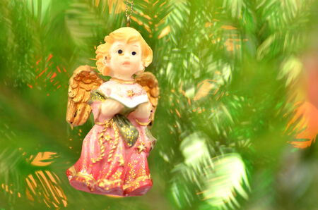 christmas decoration, figure of little angel singing carols against bokeh backgroundの写真素材