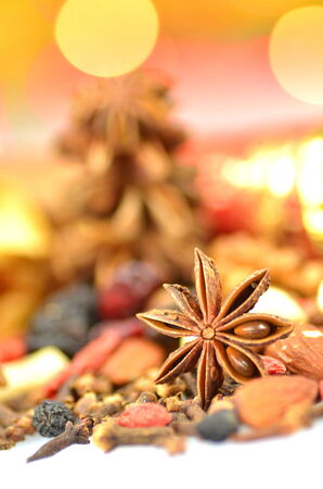christmas spices, nuts and dried fruits on bokeh background の写真素材