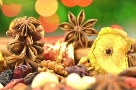 christmas spices, nuts and dried fruits on bokeh background の写真素材