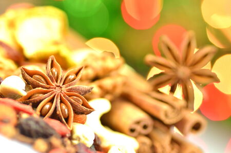 christmas spices, nuts and dried fruits on bokeh background の写真素材