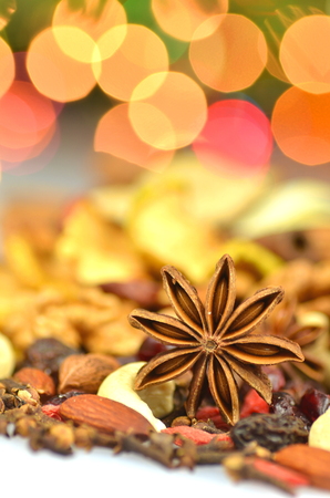 christmas spices, nuts and dried fruits on bokeh background の写真素材