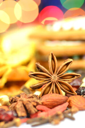 christmas spices, nuts, cookies and dried fruits on bokeh background の写真素材