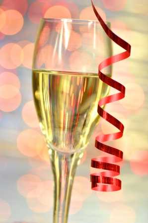 a glass of champagne against bokeh backgroundの写真素材