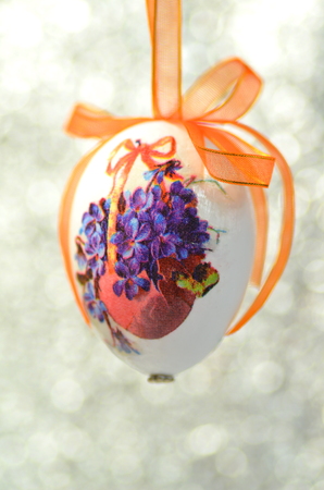 Easter egg decorated with flowers made by decoupage technique on bokeh backgroundの写真素材