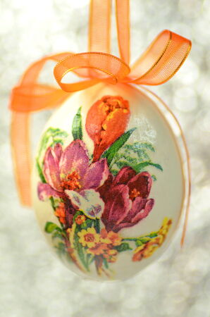 Easter egg decorated with flowers made by decoupage technique on bokeh backgroundの写真素材