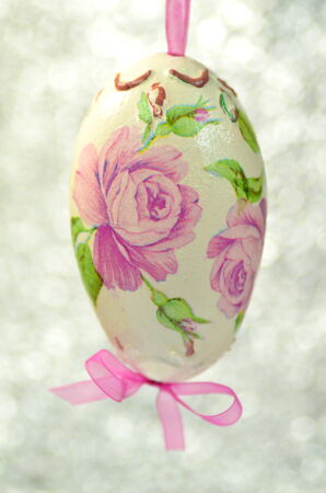 Easter egg decorated with flowers made by decoupage technique on bokeh backgroundの写真素材