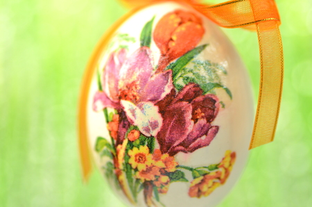 Easter egg decorated with flowers made by decoupage technique on green backgroundの写真素材