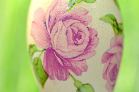 Easter egg decorated with flowers made by decoupage technique on green backgroundの写真素材