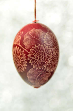 Traditional scratched handmade Easter egg on bokeh backgroundの写真素材