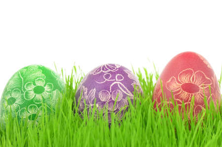 three scratched handmade Easter eggs in the grass isolated on white backgroundの写真素材