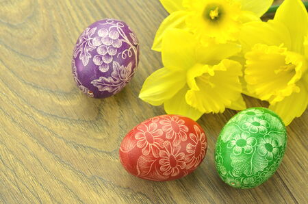 scratched handmade Easter eggs and daffodil flowersの写真素材