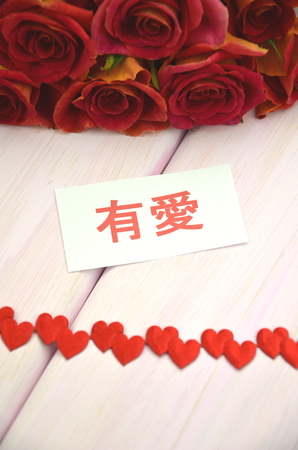 with love wishes in chinese and bouquet of gorgeous red rosesの写真素材