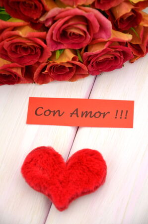 with love wishes in spanish and bouquet of gorgeous red rosesの写真素材