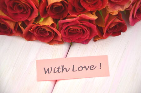 with love wishes and bouquet of gorgeous red rosesの写真素材