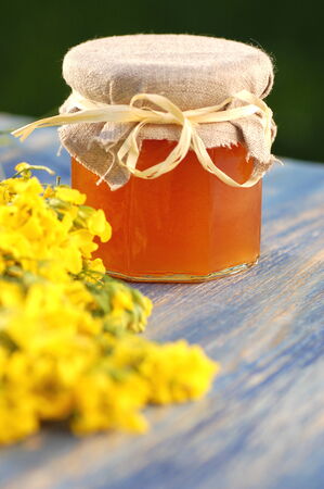 jar of delicious honey with rapeseed flowersの写真素材