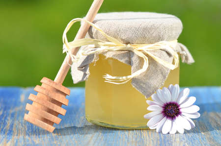 jar of delicious honey, flower and honey dipper in apiaryの写真素材