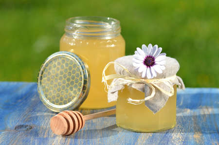 jars of delicious honey, flower and honey dipper in apiaryの写真素材