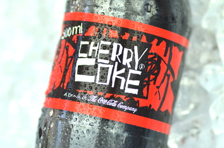 Bottle of Cherry Coke drink on ice cubesのeditorial素材