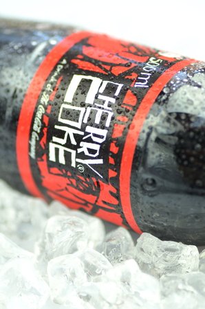 Bottle of Cherry Coke drink on ice cubesのeditorial素材