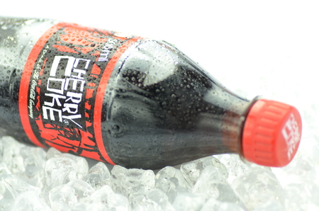 Bottle of Cherry Coke drink on ice cubesのeditorial素材