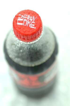 Bottle of Cherry Coke drink on ice cubesのeditorial素材