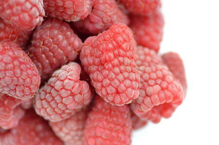 closeup of ripe, fresh and sweet raspberries isolated on whiteの写真素材