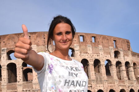 beautiful attractive brunette tourist girl close to majestic Colosseum in Rome, Italyの写真素材