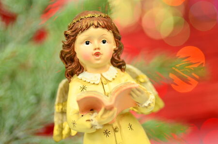 christmas decoration, figure of singing angel against bokeh backgroundの写真素材
