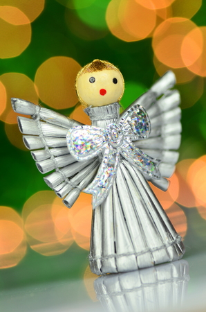 christmas decoration, silver angel made of straw against bokeh backgroundの写真素材